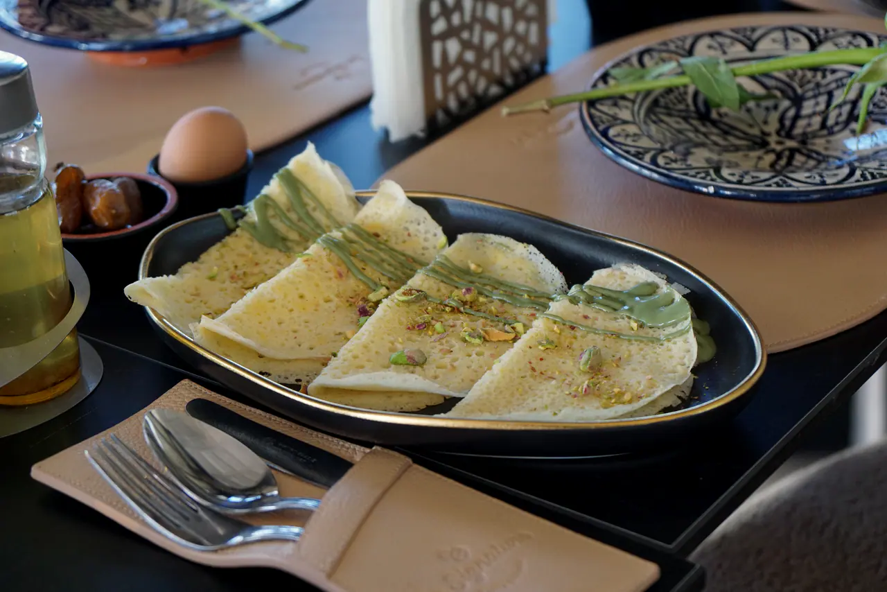 Msemen à la pistache, œuf et dattes sur une assiette de Fès